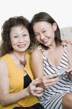 Portrait of a senior woman and her granddaughter sitting together and smiling