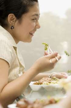 Side profile of a female office worker having lunch and smiling