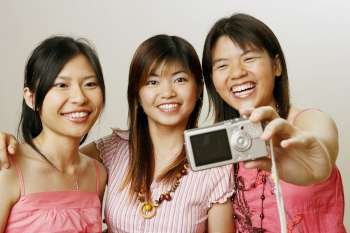 Close-up of three young women taking a picture of themselves