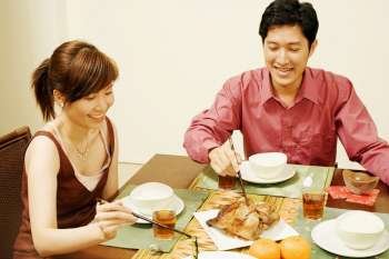 Young couple sitting at the dining table and eating food