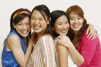 Portrait of four young women hugging each other and posing