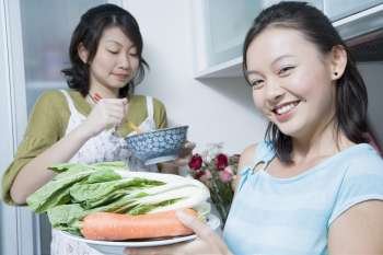 Two young women preparing food in a kitchen