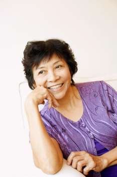 Close-up of a mature woman sitting on a couch and smiling
