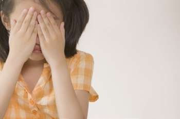 Close-up of a girl crying and hiding her face