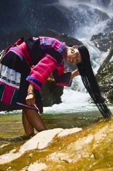 Portrait of a mature woman washing her hair in a waterfall, Jinkeng Terraced Field, Guangxi Province, China