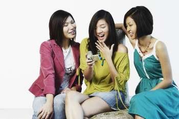 Three young women looking at a digital camera
