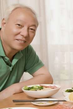 Portrait of a mature man sitting at a dining table