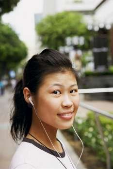 Portrait of a young woman wearing headphones and listening to music
