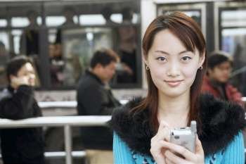 Portrait of a young woman operating a mobile phone with a digitized pen