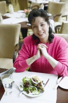 Portrait of a mature woman seated at the table in a restaurant smiling