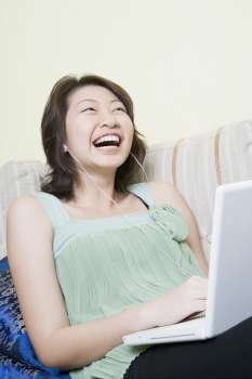 Young woman using a laptop and laughing