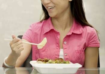 Close-up of a female office worker having lunch and smiling