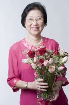 Portrait of a senior woman holding a bouquet of flowers