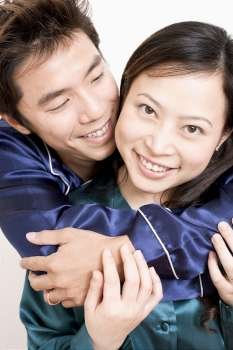 Close-up of a mid adult man hugging a young woman from behind