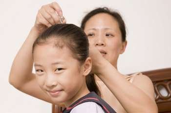 Mother adjusting her daughter´s hair with a hair clip