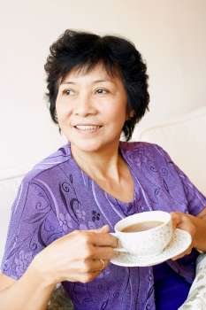 Close-up of a mature woman holding a cup of tea