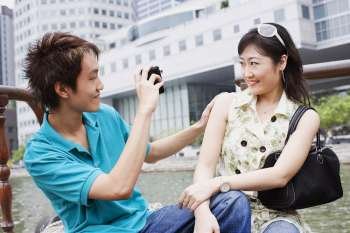 Close-up of a young man taking video of a young woman