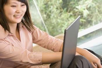 Young woman looking at a laptop and smiling