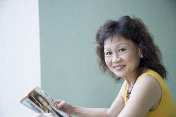 Portrait of a senior woman holding a magazine and smiling