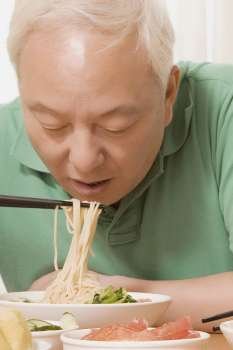 Close-up of a mature man having noodles