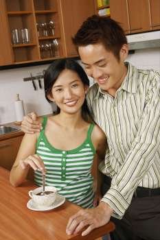 Portrait of a young couple smiling at a kitchen counter