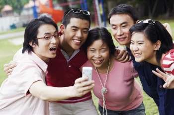 Five people looking at a mobile phone