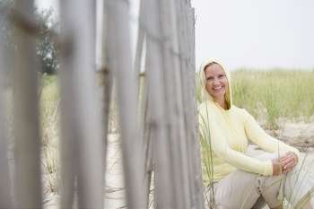 Portrait of a mid adult woman sitting near a fence and smiling