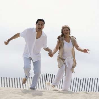Portrait of a mature couple running on the beach