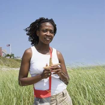 Mid adult woman holding starfish and smiling