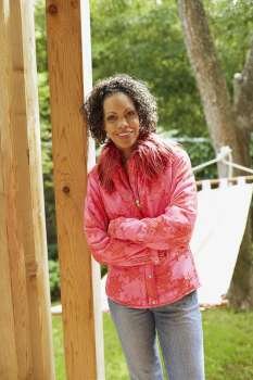 Portrait of a mature woman leaning against a wooden pole