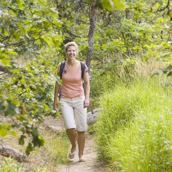 Mature woman walking in a forest and smiling