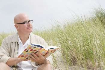 Mature man holding a book and looking away
