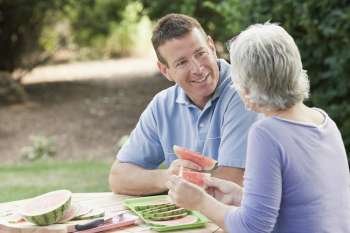 Mature couple eating watermelon slices