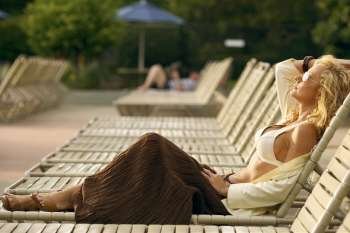 Side profile of a mature woman reclining on a lounge chair