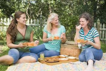 Two mature women and a young woman having picnic in a park