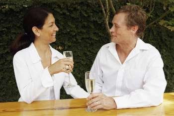 Mature couple holding champagne flutes and looking at each other
