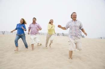 Two couples running on the beach