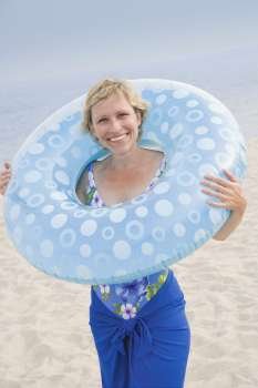 Portrait of a mature woman holding an inflatable ring and smiling