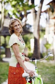 Portrait of a mature woman standing with a bicycle