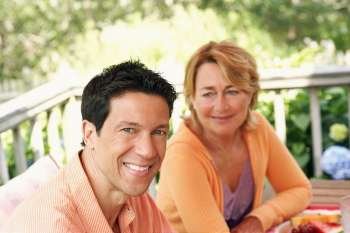 Mature man and mature woman sitting at the table and smiling