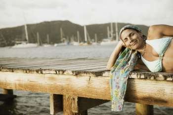 Mid adult woman lying on a pier and smiling