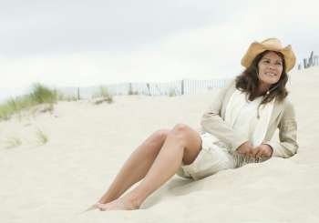 Mature woman reclining on the beach and smiling