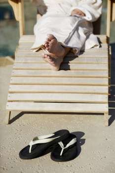 Low section view of a woman sitting on a lounge chair