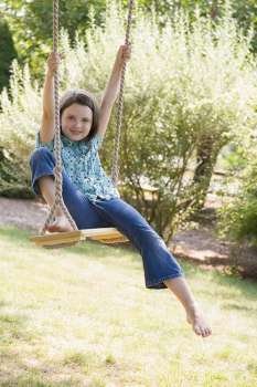 Portrait of a girl swinging on a rope swing