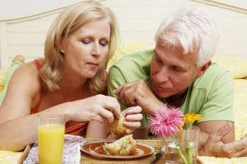 Close-up of a mature couple having breakfast in bed