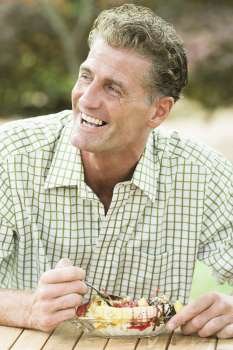 Mature man eating an ice cream and smiling