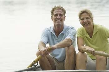 Portrait of a mature couple rowing a boat and smiling