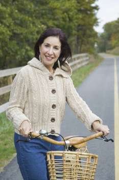 Portrait of a mature woman holding a bicycle and smiling