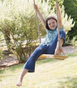 Girl swinging on a rope swing