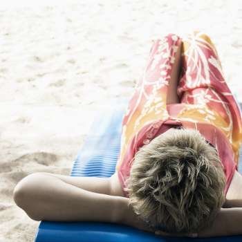 Mature woman lying on a float on the beach